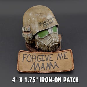 Könnte beinhalten: Ein verwitterter, beigefarbener Helm mit grün getönten Gläsern und einem Atemschutzgerät, zusammen mit einem passenden Aufnäher. Der Aufnäher lautet "FORGIVE ME MAMA". Der Aufnäher misst ca. 10 cm x 4,4 cm.
