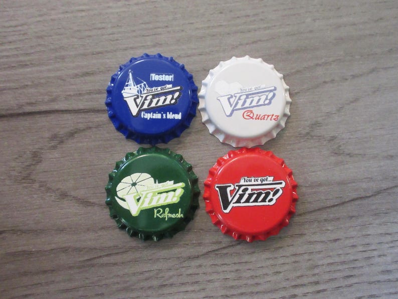May include: Four circular metal bottle caps featuring the Vim! logo. The top left is blue with 'Tester' and 'Captain's blend'. The top right is white with 'Quartz'. The bottom left is green with 'Refresh'. The bottom right is red with 'You've got... Vim!'.