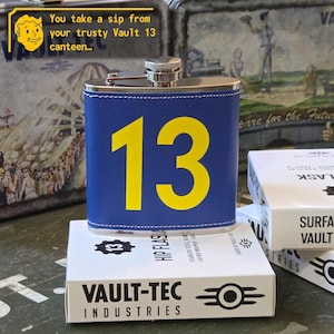 Peut inclure: Une flasque en acier inoxydable bleue gainée de cuir avec le numéro 13 en grande police jaune sur le devant. La flasque présente un bouchon à vis argenté et des coutures blanches sur les bords. Elle est présentée avec son emballage blanc.