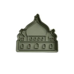 Può includere: Un tagliabiscotti verde salvia a forma di moschea. Il tagliabiscotti presenta una cupola centrale, finestre ad arco e strutture a forma di minareto. Il design è dettagliato e adatto per creare biscotti a tema.