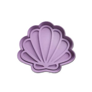 Op de afbeelding: Een paarse siliconen mal in de vorm van een schelp, voor bakken of knutselen.