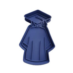 May include: A navy blue graduation gown and mortarboard cookie cutter. The cookie cutter is made of plastic and is in the shape of a graduation cap and gown. The design is a single piece with a detailed outline.