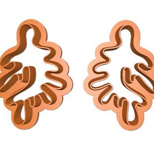 May include: Two orange cookie cutters shaped like stylized oak leaves.