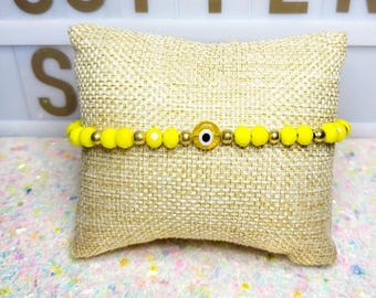 Pulsera ajustable con cordón negro contra el mal de ojo y protección amarilla
