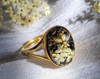 Goldener Ring mit gepressten Blumen und Bienen