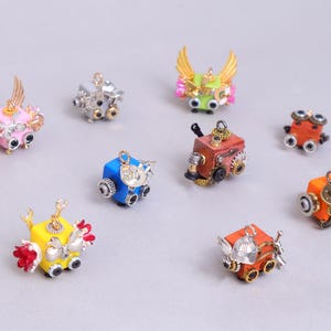 May include: A selection of miniature steampunk robot figurines in various colours. Each robot has intricate details, including gears, wings, and metallic accents. The robots are painted in shades of pink, blue, yellow, orange, and green.