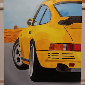 May include: A painting of a yellow sports car, viewed from the rear quarter. The car has black tires and a silver wheel. The background features a light blue sky and a desert landscape. The car's taillights are red and orange.