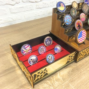 Op de afbeelding: Een houten displaykast met een lade met rode viltvoering voor het opbergen en tentoonstellen van challenge-munten. De lade heeft zes vakken voor munten. De kast heeft een meertraps displaygebied voor extra munten.