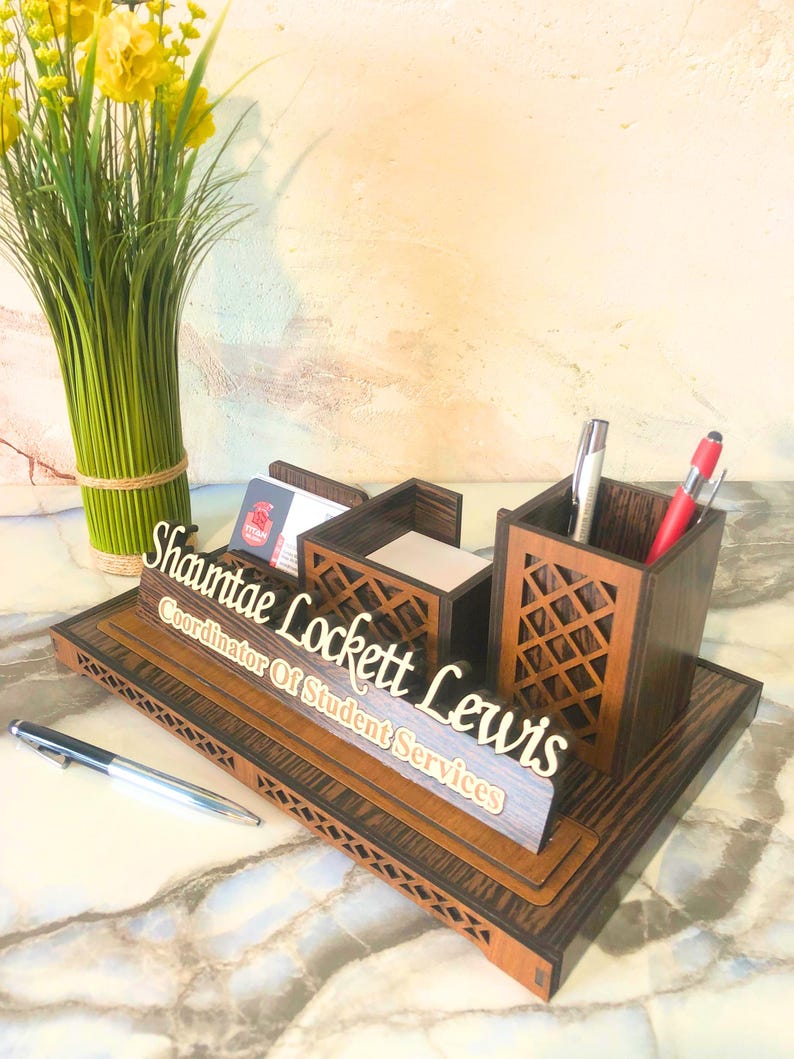 May include: Wooden desk organizer with a nameplate that reads "Shantae Lockett Lewis, Coordinator of Student Services". The organizer has compartments for pens, pencils, and business cards.