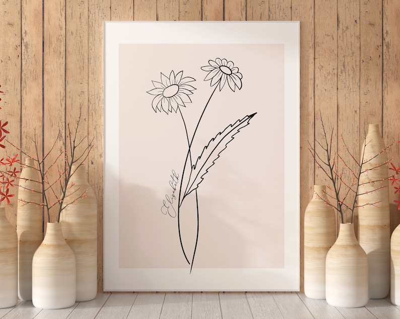 May include: A white frame with a light pink background featuring a black line drawing of two stylized daisies with a single leaf. The text "Elizabeth" is written in cursive on the right side of the image.