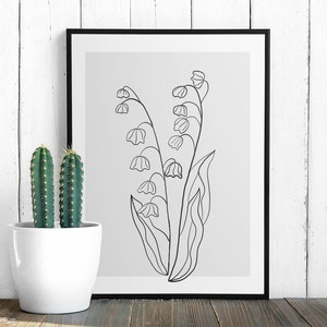 May include: A black and white line drawing of lily of the valley flowers in a simple, minimalist style. The drawing is on a light grey background and is framed in a black frame.