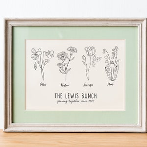 May include: A framed print with a light green mount and a white background. The print features four black and white line drawings of flowers, each labelled with a name: Peter, Kristen, Jennifer, and Noah. Below the flowers is the text "THE LEWIS BUNCH growing together since 2010".
