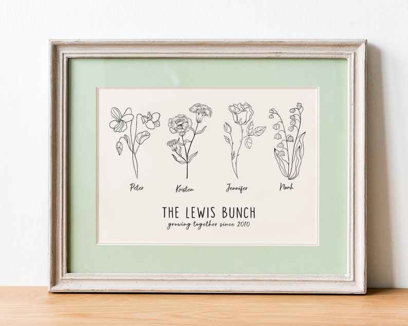 May include: A framed print with a light green mount and a white background. The print features four black and white line drawings of flowers, each labelled with a name: Peter, Kristen, Jennifer, and Noah. Below the flowers is the text "THE LEWIS BUNCH growing together since 2010".