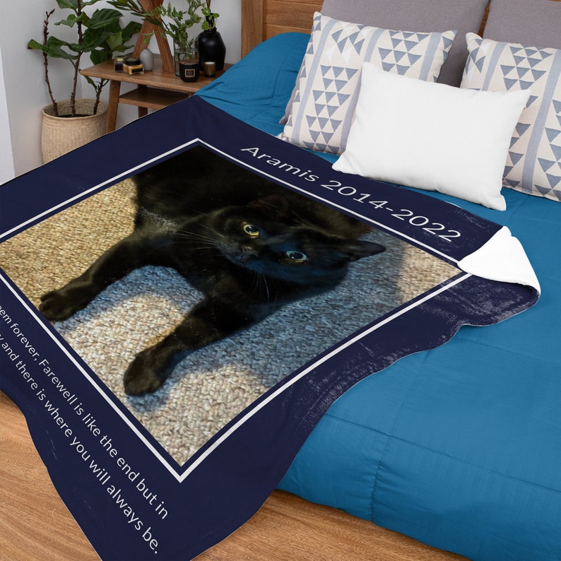 May include: A navy blue memorial blanket with a white border and a photo of a black cat. The text "Aramis 2014-2022" is printed on the blanket. The text "Forever, Farewell is like the end but in and there is where you will always be." is printed on the blanket.