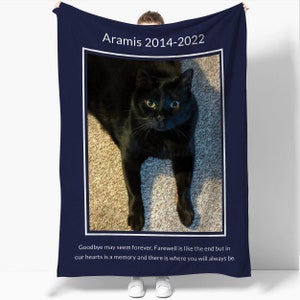 May include: A navy blue memorial blanket with a photo of a black cat and the text "Aramis 2014-2022". The text below the photo reads "Goodbye may seem forever, Farewell is like the end but in our hearts is a memory and there is where you will always be."