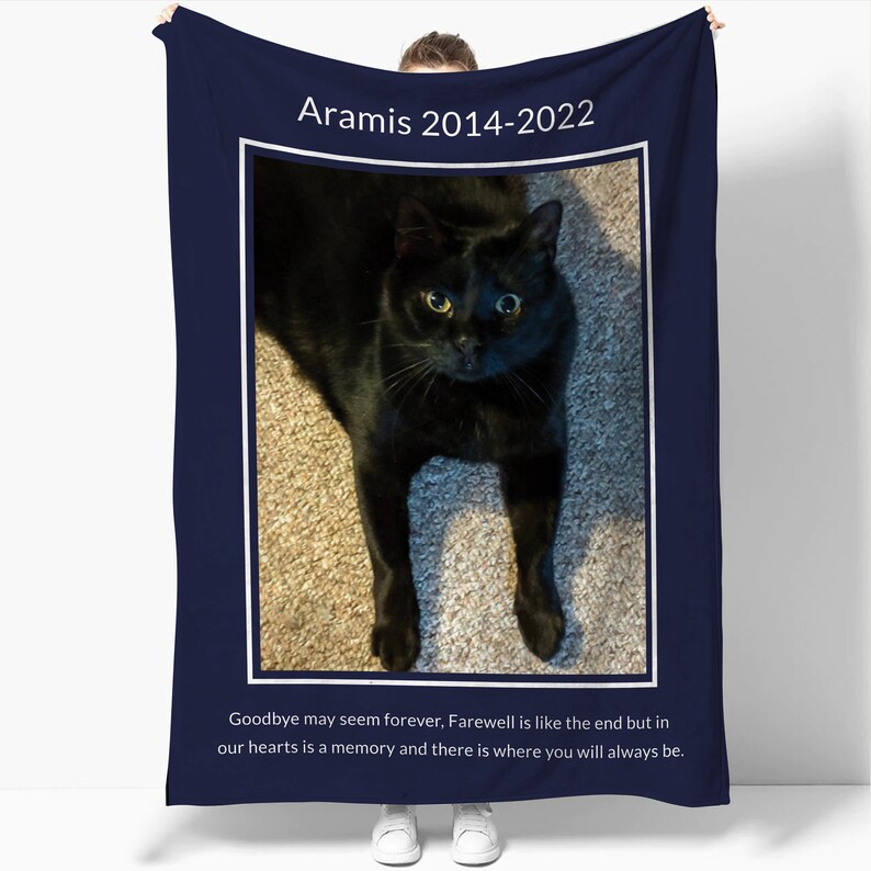 May include: A navy blue memorial blanket with a photo of a black cat and the text "Aramis 2014-2022". The text below the photo reads "Goodbye may seem forever, Farewell is like the end but in our hearts is a memory and there is where you will always be."