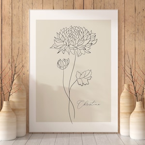 May include: A black and white line drawing of a flower with the name "Christina" written below it. The drawing is on a beige background and framed in a white frame.