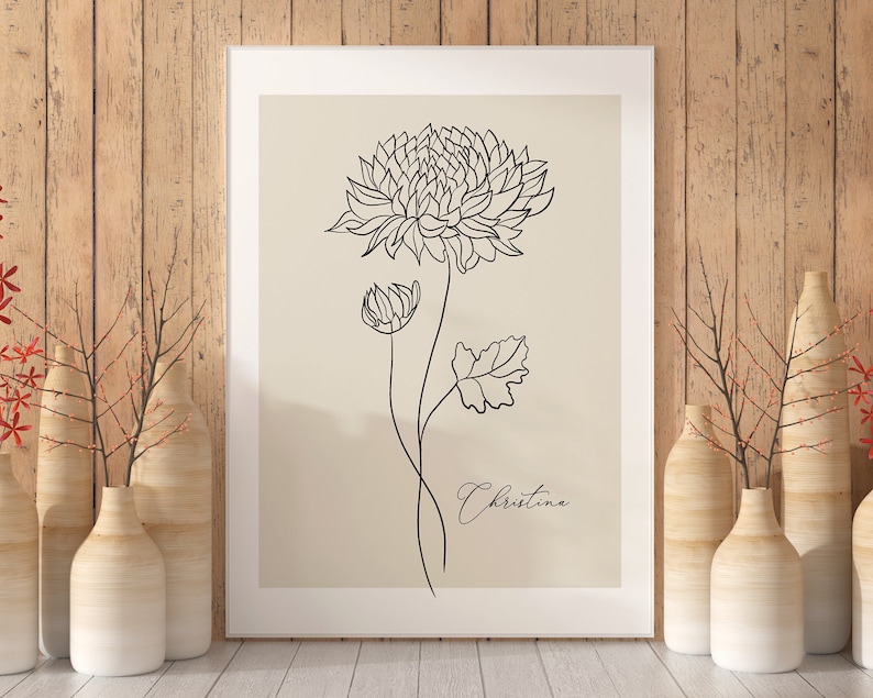 May include: A black and white line drawing of a flower with the name "Christina" written below it. The drawing is on a beige background and framed in a white frame.
