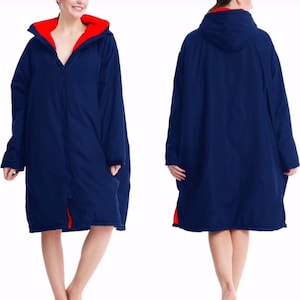 Może przedstawiać: Granatowy szlafrok do przebierania z jasnoczerwoną podszewką i kapturem. Szlafrok posiada zamek błyskawiczny na całej długości i kieszenie. Model prezentuje przód i tył szlafroka. Idealny do aktywności na świeżym powietrzu.