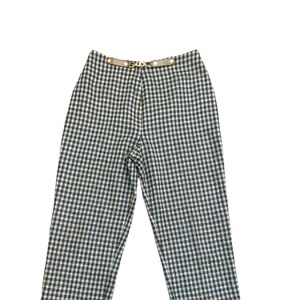 May include: A pair of high-waisted pants with a checkered pattern in shades of brown, blue, and white. The pants have a belt loop and a gold buckle.