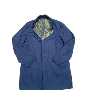 May include: A navy blue long coat with a camouflage lining. The coat has a button closure and two pockets.