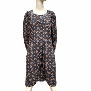 Puede incluir: Un vestido largo de manga larga, azul oscuro, con botones en la parte delantera y estampado floral marrón y blanco.