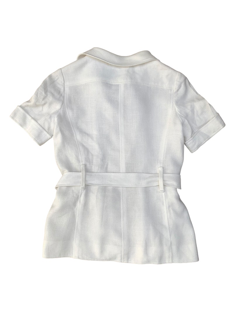 May include: A white linen short-sleeved shirt with a collar and a belt.