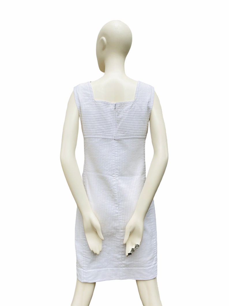 May include: A white sleeveless dress with a striped pattern and a zipper closure in the back.