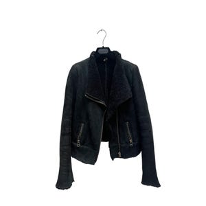 May include: A black faux fur lined jacket with a zipper closure and two zippered pockets on the front.
