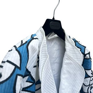 Peut inclure: Une veste &agrave; motif blanc et bleu avec un col blanc et un cintre noir.
