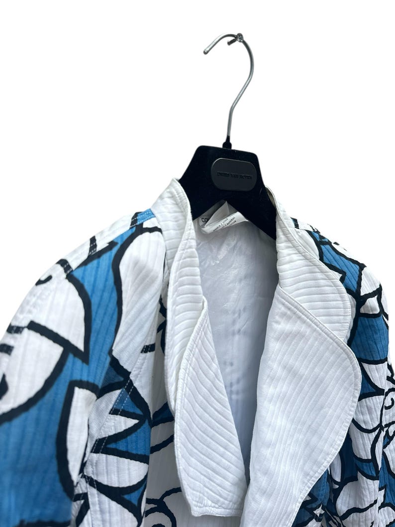 Peut inclure: Une veste &agrave; motif blanc et bleu avec un col blanc et un cintre noir.