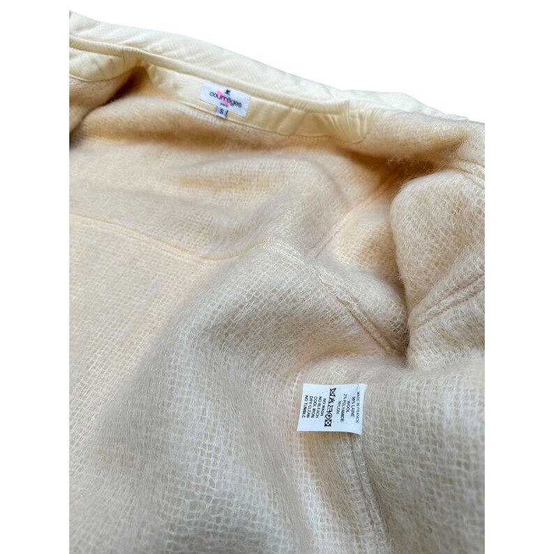 May include: A cream-colored jacket with a soft, fuzzy lining. The jacket has a label that reads "COLOURTONE" and "MADE IN ITALY".
