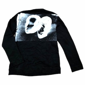 May include: Black long-sleeve shirt with a white graphic print of two faces on the back.
