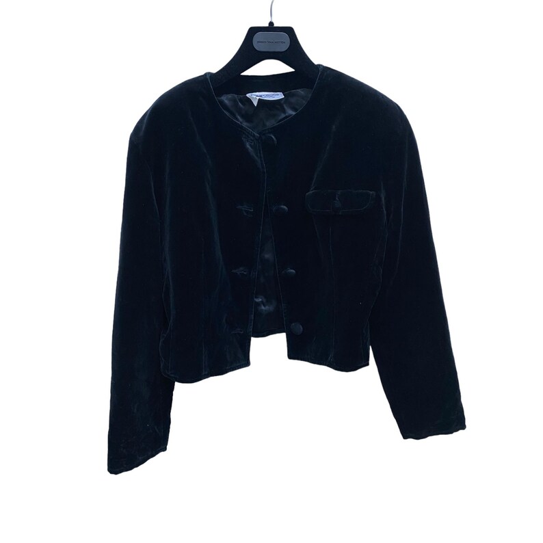 May include: A black velvet cropped jacket with a button closure and a pocket on the left side.