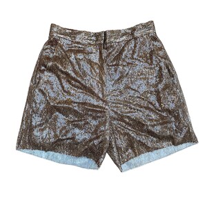 May include: A pair of brown sequined shorts with a light blue denim hem.