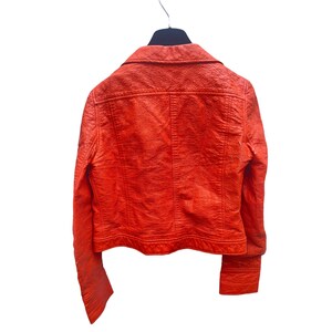 May include: A bright orange leather jacket with a zipper closure and long sleeves.