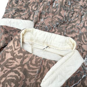 Puede incluir: Conjunto de dos piezas con un estampado de rosas en tonos marr&oacute;n y rosa. El conjunto incluye una parte superior con cuello y pu&ntilde;os color crema. La etiqueta dice "MME DES".