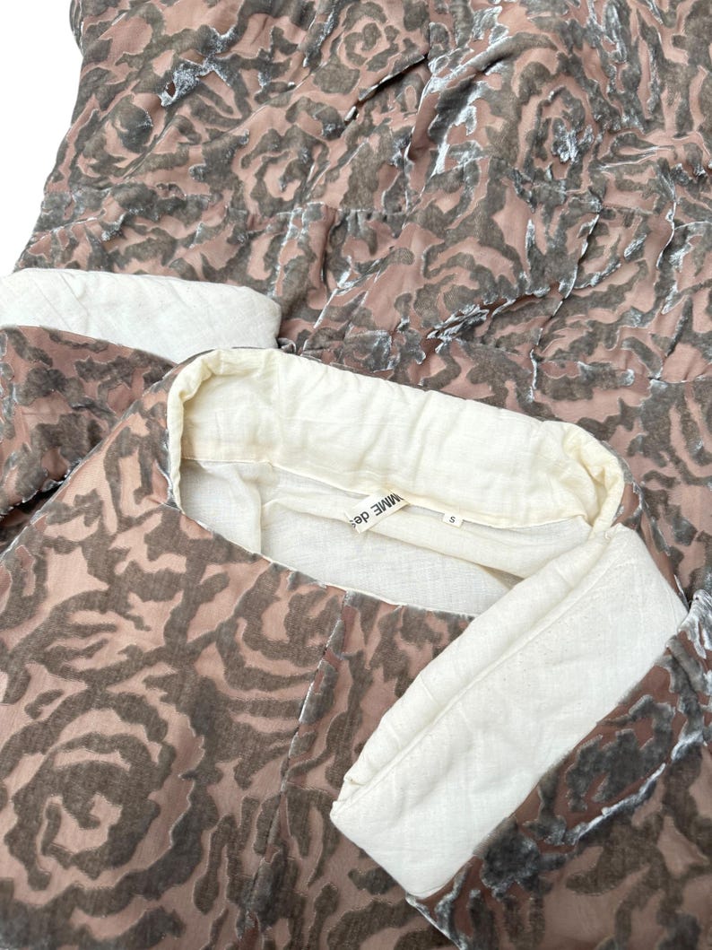 Puede incluir: Conjunto de dos piezas con un estampado de rosas en tonos marr&oacute;n y rosa. El conjunto incluye una parte superior con cuello y pu&ntilde;os color crema. La etiqueta dice "MME DES".