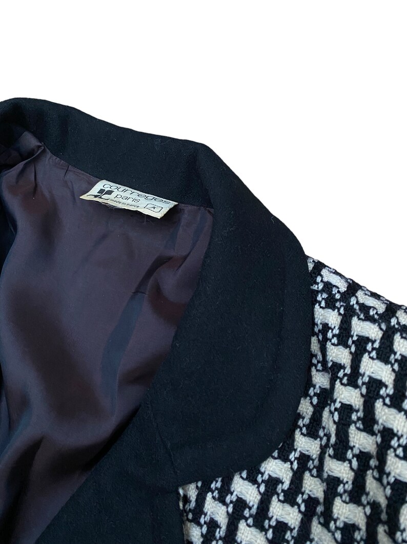 May include: Black and white patterned blazer with a black collar. The label inside the blazer reads "Courreges Paris" and "Made in France".