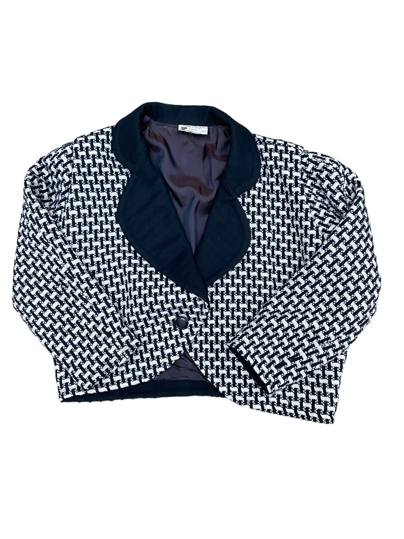 May include: A black and white patterned blazer with a black collar and a single button closure.
