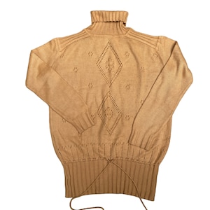 May include: A tan turtleneck sweater with a diamond-shaped pattern and a drawstring at the bottom.