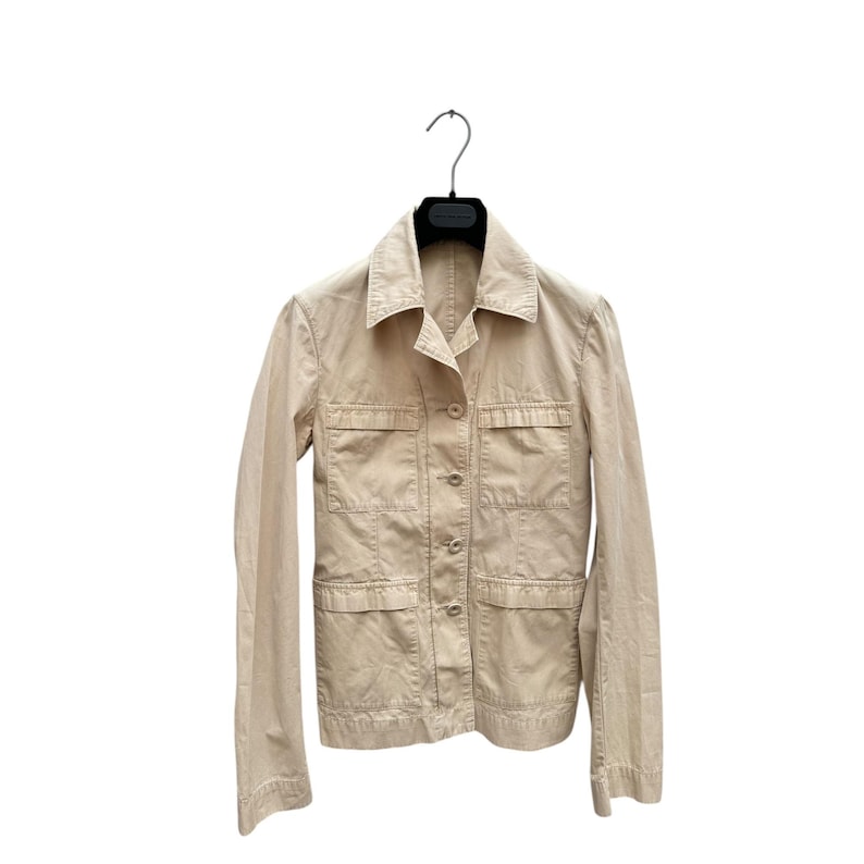 May include: A beige utility jacket with a button closure and multiple pockets.