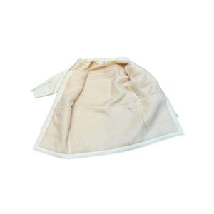 May include: A white fleece-lined jacket with a zipper closure. The jacket is turned inside out to show the fleece lining.