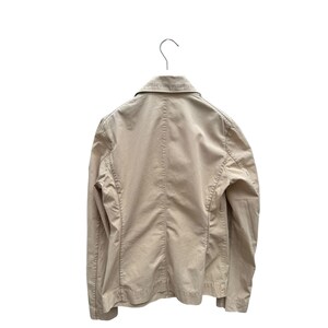 May include: A beige lightweight jacket with a button closure and long sleeves.