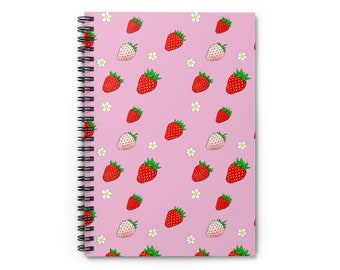 May include: A pink spiral notebook with a repeating pattern of red strawberries and white flowers.