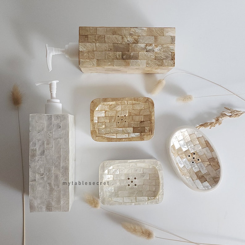 Puede incluir: Conjunto de cuatro accesorios de ba&ntilde;o hechos de azulejos de n&aacute;car blanco y beige. El conjunto incluye un dispensador de jab&oacute;n, un jabonera y dos jaboneras m&aacute;s peque&ntilde;as.