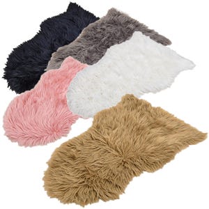 Könnte beinhalten: Eine Auswahl an Kunstfellteppichen in verschiedenen Farben, darunter Marineblau, Grau, Rosa, Weiß und Beige. Die Teppiche haben eine zottelige Textur und eine unregelmäßige Form, geeignet für die Inneneinrichtung.