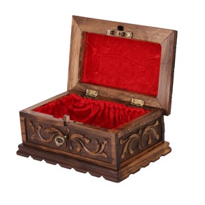 May include: A wooden box with intricate carvings and a red velvet lining. The box has a brass handle and hinges.