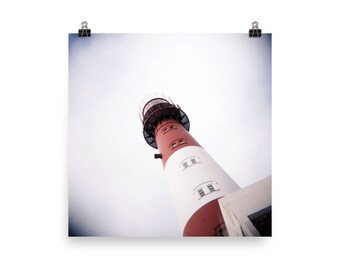 May include: A red and white lighthouse with a black metal railing at the top. The lighthouse is against a cloudy sky.