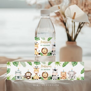 Puede incluir: Una botella de agua transparente con una etiqueta personalizada con animales de la jungla y el texto "1er cumpleaños de Harrison". La etiqueta incluye una jirafa, un león, una cebra y otros animales. Hay una etiqueta a juego debajo de la botella.